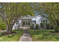 Charming home with a brick facade, inviting front porch, and mature trees in a well-manicured lawn at 2522 N Roxboro St, Durham, NC 27704