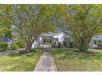 Charming home with a walkway leading to the front porch and beautiful trees providing shade at 2522 N Roxboro St, Durham, NC 27704
