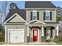 Charming two-story home with a red door, a white garage door and a manicured lawn at 322 Bluejay St, Clayton, NC 27520