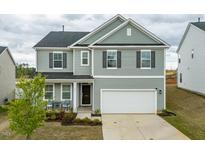 Charming two-story home featuring a two car garage, manicured lawn and covered front porch at 35 October Glory Way, Franklinton, NC 27525