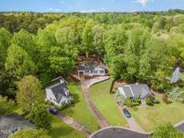 An aerial view of a white single-Gathering home nestled among lush green trees at 508 Baygall Rd, Holly Springs, NC 27540