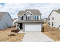 Charming two-story home featuring a two-car garage, stone accents, and a well-manicured lawn at 512 Oak Holly Ln, Zebulon, NC 27597