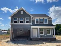 Charming two-story home featuring gray siding, white trim, and an inviting front porch at 54 Grove Township Way, Angier, NC 27501