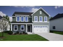Charming two-story home boasts a manicured lawn, attached two-car garage, and a welcoming covered front porch at 54 Grove Township Way, Angier, NC 27501