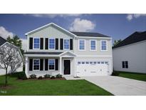 Two story home featuring black shutters and a two car garage at 59 Grove Township Way, Angier, NC 27501