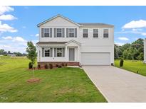 Charming two-story home with a well-manicured lawn, attached two-car garage, and classic architectural details at 59 Grove Township Way, Angier, NC 27501