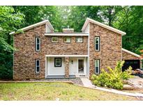 Beautiful two-story home with stone exterior, black-trimmed windows and attached garage at 6409 Lakeland Dr, Raleigh, NC 27612