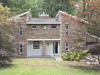 Beautiful stone-clad two-story home with a well-manicured lawn and colorful trees at 6409 Lakeland Dr, Raleigh, NC 27612