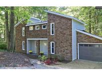 Contemporary home with stone facade, clean lines, and an attached garage for modern living at 6409 Lakeland Dr, Raleigh, NC 27612
