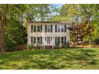 Charming two-story home with a well-manicured lawn and blue shutters adding a touch of classic elegance at 7433 Deer Track Dr, Raleigh, NC 27613