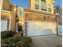 Charming townhome with stone accents, attached two-car garage, and inviting entrance at 8002 Upper Lake Dr, Raleigh, NC 27615