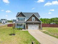 Charming two-story home boasts a manicured lawn, two-car garage, and inviting front porch at 85 Sun Mdw Cir, Benson, NC 27504