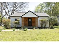Charming home with white siding, a modern black front door, and a well-manicured lawn at 1015 Washington St, Burlington, NC 27217