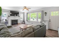 Bright living room featuring a fireplace, large windows and cozy seating area at 1017 Southerlund Rd, Garner, NC 27529