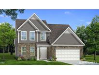 Charming two-story home featuring a mix of stone and siding, complemented by a well-manicured lawn and landscaping at 1028 Channel Drop Lp, Zebulon, NC 27597