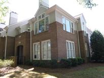 Brick townhome featuring multiple windows, neutral siding, landscaped lawn, and a covered doorway entrance at 1062 Washington St # 201, Raleigh, NC 27605