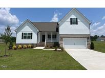 Charming white two-story home with well-manicured lawn and inviting curb appeal at 11430 International Dr, Middlesex, NC 27557