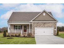 Charming new home featuring stone accents, a covered porch, and an attached two-car garage at 11450 International Dr, Middlesex, NC 27557