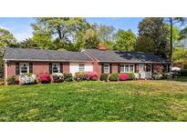 Charming one-story brick home with black shutters and colorful azaleas in the front yard at 118 Shannon Dr, Burlington, NC 27215