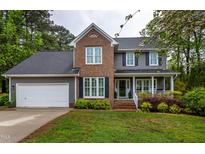 Charming two-story home with a brick and gray facade, lush landscaping, and a welcoming front porch at 1809 Green Ford Ln, Apex, NC 27502