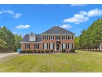 Charming two-story brick home with a manicured lawn and lush greenery at 2804 Brenfield Dr, Raleigh, NC 27606