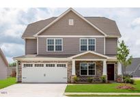 Two-story home features stone accents, attached two-car garage, and well-maintained landscaping at 302 Shiloh Way, Mebane, NC 27302