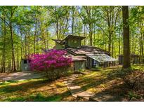 Unique home exterior featuring a beautiful sunroom and vibrant landscaping at 3719 W Cornwallis Rd, Durham, NC 27705