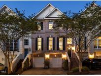 Beautiful brick townhouse with garage and manicured landscaping at dusk at 3920 Bentley Brook Dr, Raleigh, NC 27612