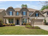 Charming two-story home with a manicured lawn, inviting entrance, and an attached two-car garage at 521 Wildwood Farm Way, Holly Springs, NC 27540