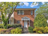 Charming brick townhouse featuring a covered entryway and well-manicured landscaping at 5900 Shady Grove Cir, Raleigh, NC 27609