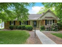 Charming brick home featuring manicured landscaping and a welcoming walkway to the front door at 704 W Front St, Burlington, NC 27215