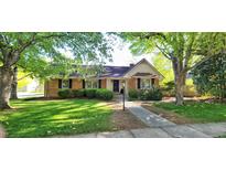 Charming brick home with mature trees, a manicured lawn, and traditional architectural details at 704 W Front St, Burlington, NC 27215