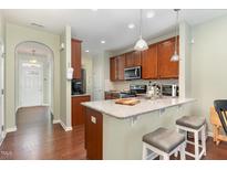 This open-concept kitchen features granite countertops, dark wood cabinets, and stainless steel appliances at 7328 Caversham Way, Raleigh, NC 27617