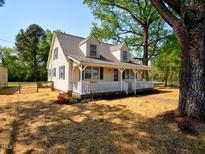 Charming home with a welcoming front porch and mature trees providing ample shade at 7702 Nc Highway 581, Kenly, NC 27542