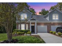 Charming two-story home boasts a well-manicured lawn, brick accents, and attached two-car garage at 9005 River Estates Dr, Knightdale, NC 27545