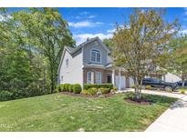 Charming two-story home with landscaped yard and mature trees on a sunny, partly cloudy day at 9005 River Estates Dr, Knightdale, NC 27545