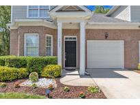 Charming brick home featuring a black front door, attached garage, and well-manicured landscaping at 9005 River Estates Dr, Knightdale, NC 27545