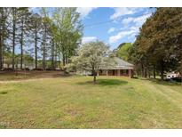 Charming single-story brick home featuring a welcoming front porch and a beautiful flowering tree at 903 Creech Rd, Garner, NC 27529