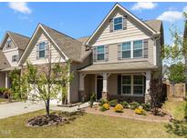 Charming two-story home with a stone facade, covered porch, and landscaped front yard at 1033 Laredo Ln, Durham, NC 27703