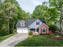 Charming home featuring a two-car garage, beautiful landscaping, and a well-maintained lawn at 105 Hein Dr, Clayton, NC 27527