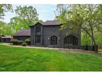 Beautiful two-story gray brick home with a well-manicured lawn and mature trees at 10805 The Olde Pl, Raleigh, NC 27614