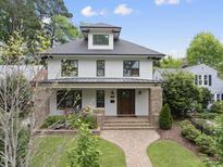 Charming two-story home featuring a manicured lawn, brick pathway, and inviting front porch at 1306 Mordecai Dr, Raleigh, NC 27604