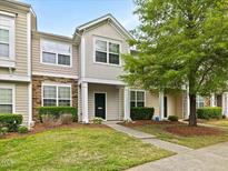 Inviting townhome featuring stone accents, neutral siding, manicured lawn, and walkway leading to the front door at 1605 Grace Point Rd, Morrisville, NC 27560