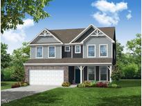 Charming two-story home boasts a stone facade, a two car garage, and beautiful landscaping at 1645 Wareham Dr, Mebane, NC 27302