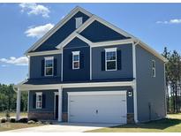 Charming two-story home with blue siding, white trim, and a welcoming two-car garage at 172 Knoll Way, Sanford, NC 27332