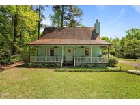 Charming home with a covered front porch, manicured lawn, and lush greenery at 209 Pen Lou Ct, Angier, NC 27501