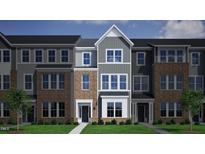 Charming townhome featuring brick and siding exterior, creating an inviting curb appeal at 311 Chesapeake Commons St # 101, Garner, NC 27529