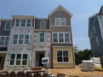 New construction townhome featuring a modern design, large windows, and durable siding, ready for customization at 311 Chesapeake Commons St # 101, Garner, NC 27529