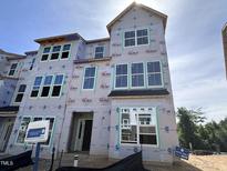 Unfinished new home exterior with visible framework, large windows, and modern architectural details in a residential area at 311 Chesapeake Commons St # 101, Garner, NC 27529