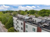 Modern townhome exterior with rooftop terraces, black railings, and brick accents at 400 W Rosemary St # 104, Chapel Hill, NC 27516